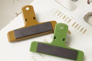 Dettaglio di clip in plastica magnetiche con fori per appendere e potenti calamite