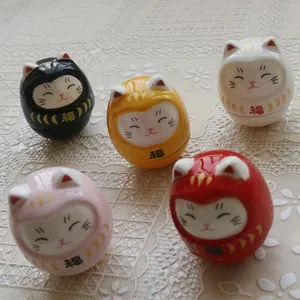 Set of five colorful ceramic Daruma fortune cat figurines with Japanese luck symbols