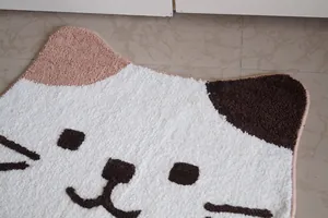 Detailed view of the soft tufted texture and cute calico cat face pattern of the floor mat