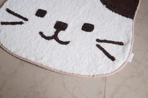 Cute calico cat-shaped non-slip floor mat with soft velvet texture on marble tile