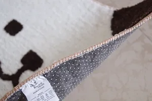 Close-up of thick plush cat mat featuring non-slip gray backing and care label details