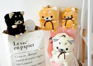 Detail of rolled plush Shiba Inu blankets with 3D ears and ribbon packaging