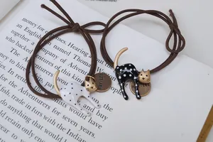 Set elastici per capelli con gatti a pois e finitura dorata su sfondo di libro