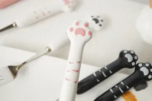 Macro de la poignée en céramique patte de chat avec détail de coussinet rose sur la cuillère
