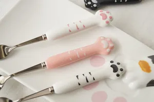 Détail de trois cuillères créatives avec manche en céramique et pattes de chat mignon