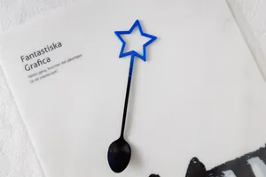 Vue détaillée d'une cuillère à café en métal avec dégradé bleu-noir et motif étoile