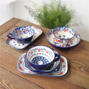 Detail of hand-painted underglaze ceramic teacup set with strawberry and berry motifs