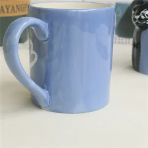 Close-up of light blue ceramic mug with white hand-drawn heart pattern and round rim