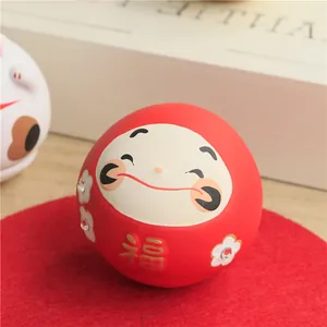 Close-up of a red ceramic Daruma doll with golden Fu character and sparkling rhinestone details