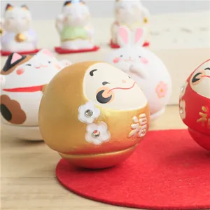 Close-up of golden Japanese Daruma doll with福 character and sparkling rhinestone details
