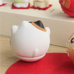 Macro view of hand-painted calico cat ceramic figurine on red felt base mat