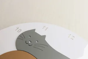 Detailansicht der japanischen Katzenwanduhr mit ausgehöhlten Ziffern 10 11 12 im Profil