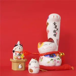 Set Maneki Neko japonés de cerámica con tres gatos de la fortuna sobre cojín rojo suave