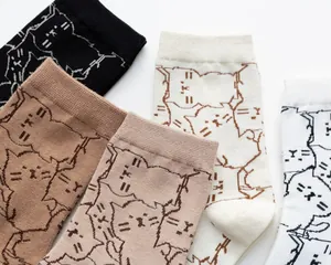 Dettaglio di un set di calze in cotone con motivi di gatti minimalisti in vari colori pastello