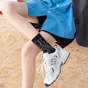 Simpatico gatto bianco su calze nere abbinate a scarpe da ginnastica bianche vintage