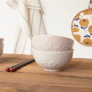 Japanese underglaze ceramic rice bowls with cherry blossom relief and wooden chopsticks