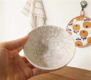Close-up of Japanese style ceramic rice bowl featuring embossed cherry blossom patterns