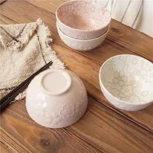 Japanese ceramic rice bowls with embossed cherry blossom patterns on wooden table