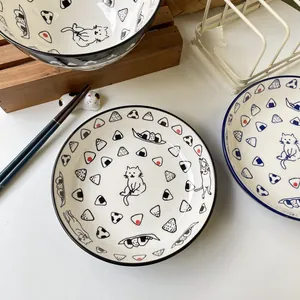 Detail of Japanese ceramic plates with hand-painted sushi cats and onigiri patterns