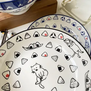 Macro detail of Japanese ceramic plate with blue rim and hand-painted cat and rice ball motifs