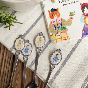 Macro view of vintage cat illustration handles on stainless steel dessert spoons