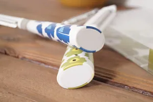 Gros plan d'éplucheurs en acier inoxydable avec poignées à motifs floraux bleus et jaunes