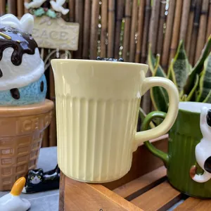 Detailed view of pale yellow ceramic mug featuring vertical ribbing and wide handle