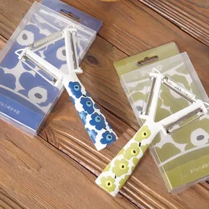 Éplucheur en Y 3-en-1 avec manche à motif floral sur une table de cuisine en bois