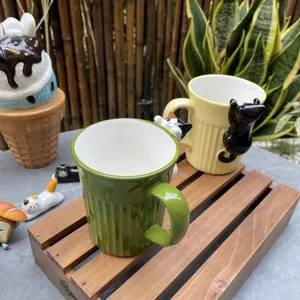 Detail of 3D ceramic cat mugs with vertical stripe texture and relief cat figures