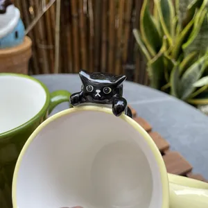 Macro shot of 3D climbing black cat ceramic mug rim in a natural garden setting