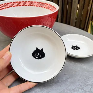 Japanese style cute black cat ceramic sauce dish held in hand to show small size scale