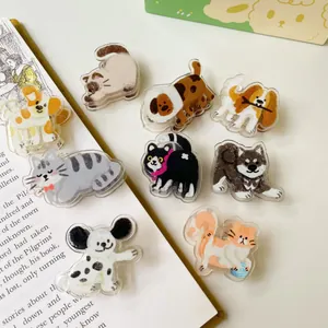 Flachbild von acht süßen Acryl-Clips mit Katzen- und Hundemotiven auf Buchseiten