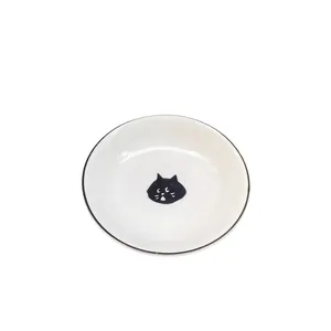 Ceramic sauce dish featuring a hand-drawn black cartoon cat head and black rim decoration