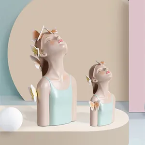 Detailed pair of pink resin lady figurines with butterflies and green tops for home decor
