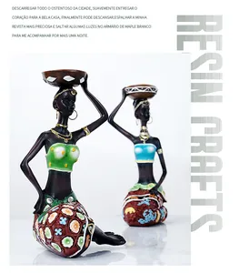 Detail of African woman resin figurine with gold jewelry and colorful floral dress