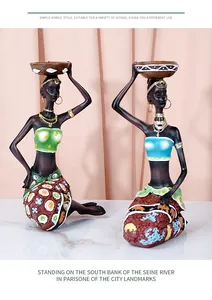 Detail of African woman resin figurines with golden jewelry and ethnic patterns