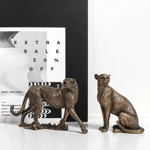 Detailed pair of leopard resin figurines with an antique bronze finish on a white surface