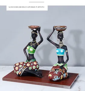 Detail of African resin candle holders with hand-painted floral dresses and golden jewelry