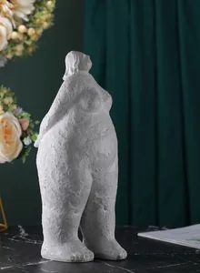 Artistic resin yoga woman sculpture featuring a grainy texture on a marble surface