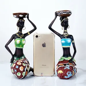 Set of two African tribal woman figurines holding candle holders with iPhone size reference
