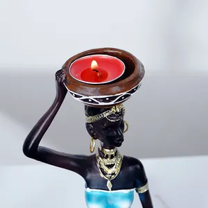 African resin woman figurine candle holder set with golden accents and teal dress