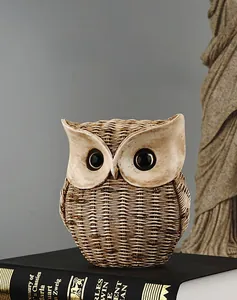 Detail of owl statue with woven resin texture placed on black books for home decor