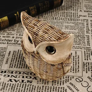 Retro resin owl figurine with woven texture on vintage book and newspaper backdrop