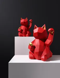 Detail of red and gold geometric Maneki Neko resin figurines on white steps