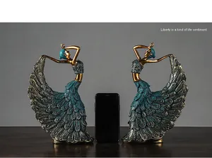 Detail view of peacock dancer sculptures showing scale with a smartphone reference