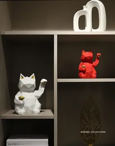 Close-up of geometric resin lucky cat statues on a modern shelf with home decor