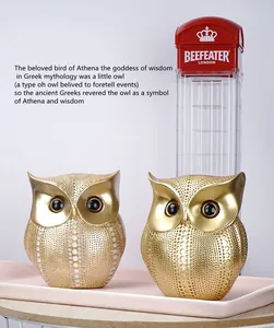 Detalle de figuras de búhos en resina dorada con texturas de puntos y ojos negros brillantes