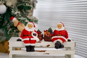Close-up of resin Santa Claus figurines with miniature tree on a rustic wooden shelf