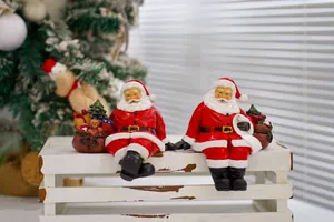 Detailed view of resin Santa Claus figurines with a gift bag and a scroll list