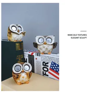 Close-up of resin solar owl lamps with hand-painted texture and LED glowing eyes